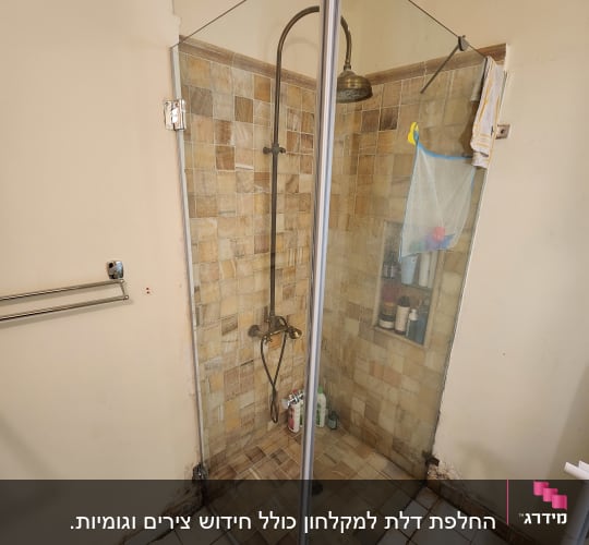 מקלחון זכוכית עם ראש מקלחת ומוצרי טיפוח